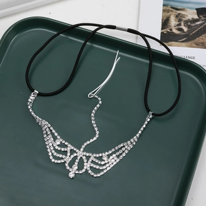 Detailed view of gothic rhinestone forehead chain with cascading crystal tassels on green tray