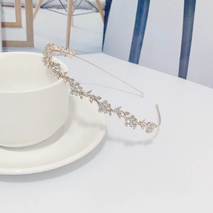 Detailed macro view of rose gold flower headband with sparkling rhinestones on white cup