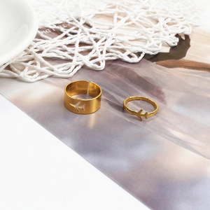 Detail of adjustable gold-tone couple rings with hollow airplane and heart design