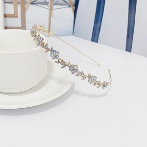 Close-up of golden floral headband with iridescent rhinestones on a white cup