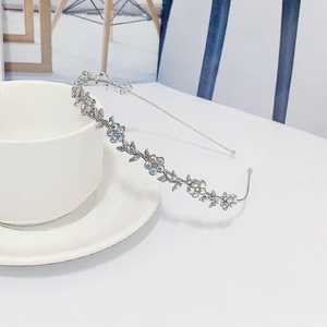 Close-up of silver flower headband with iridescent AB rhinestones by a coffee cup