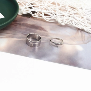 Close-up of vintage silver dinosaur couple rings with hollow silhouette on green plate