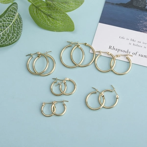 Set of six pairs of minimalist gold hoop earrings in various sizes on a blue background