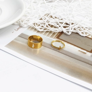 Close-up of gold adjustable couple rings set with lightning bolt cutout and charm detail