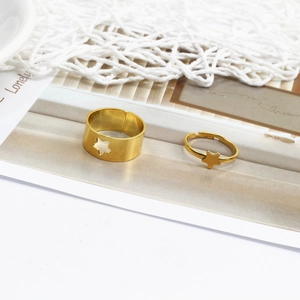Detail of gold-plated star rings set with openwork and 3D star charms for couples