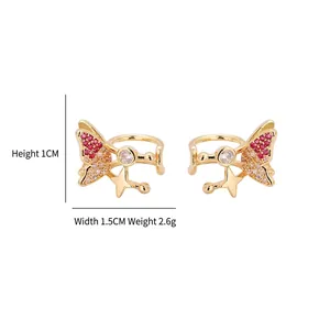 Clip d'oreille papillon doré avec oxydes de zirconium roses et blancs sur fond blanc