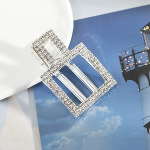 Barrette géométrique argentée avec strass blancs sur un fond décoratif élégant