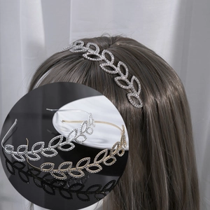 Detailed view of rhinestone leaf headband showing silver and gold plating textures