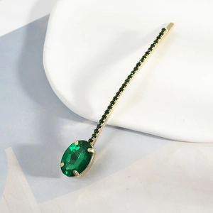 Elegant gold hair clip featuring a large oval green gemstone and faceted green crystals
