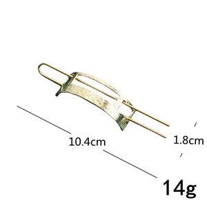 Detail view of a gold-toned hammered metal hair pin with 10.4cm length specifications