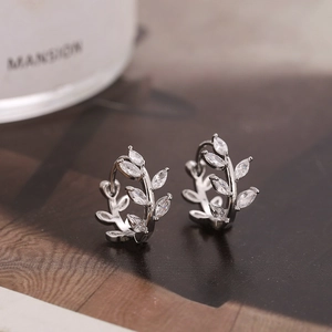 Macro shot of silver-colored leaf hoop earrings with marquise-cut zircon stones