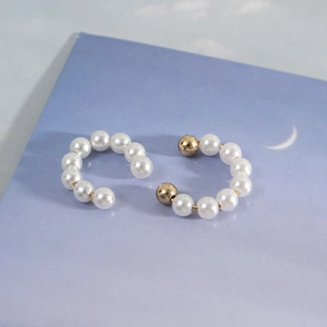 Elegant C-shaped ear cuffs with white faux pearls and gold metal beads on artistic card