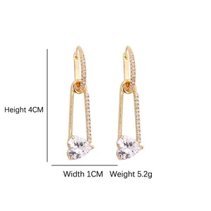 Golden safety pin earrings with sparkling zircon heart pendant and pave diamond accents