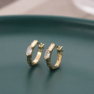 Créoles géométriques dorées avec zircon ovale et texture ondulée de style élégant