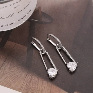 Silver safety pin earrings with micro-paved zircons and a heart-shaped gemstone drop