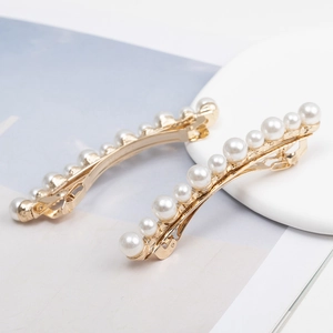 Elegant pair of gold-tone pearl hair clips with gradient white beads on white tray