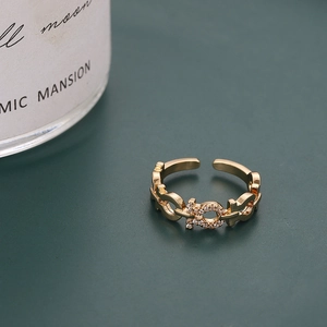Bague géométrique dorée avec oxydes de zirconium sur un fond vert foncé élégant