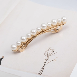 Elegant gold hair clip featuring ten gradient white pearls arranged in a graceful curved line