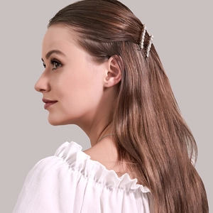 Gros plan de barrettes à fleurs en strass portées de profil sur une chevelure brune