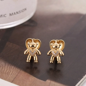 Boucles d'oreilles ours doré avec zircon en cœur sur un fond esthétique chaleureux