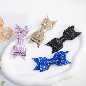Set of four glitter bow hair clips in purple, gold, black, and blue colors