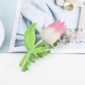 Detailopname van een matte tulp haarklem met roze gradiënt bloemblaadjes en groen blad