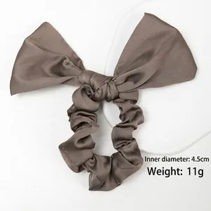 Détail du chouchou nœud en satin taupe avec diamètre de 4,5cm et un poids de 11g