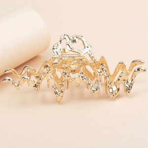 Large liquid metal hair claw clip in glossy gold with unique lava texture for women