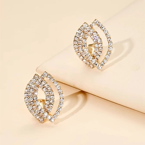 Luxury gold geometric leaf earrings with micro-pave crystals on a minimalist display stand