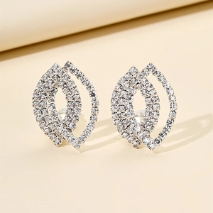 Macro detail of geometric leaf-shaped silver earrings with sparkling pavé crystals