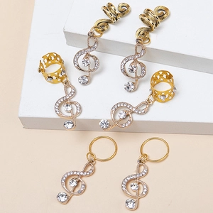 Détail de bijoux de cheveux dorés avec breloques clé de sol et cristaux étincelants