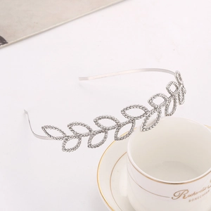 Elegant silver leaf rhinestone headband for women on a bone china cup background
