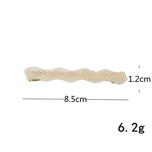 Detail view of wavy cream hair clip with gold lines showing 8.5cm length and dimensions
