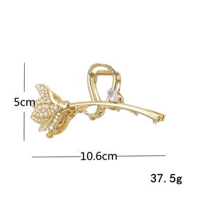 Elegant gold lotus hair claw with white pearls and rhinestones on a white background