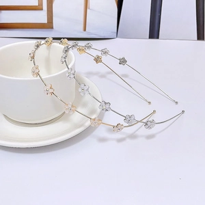 Detalle de diademas de flores ojo de gato doradas y plateadas con perlas en una taza