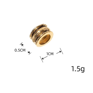 Macro detail of a 1cm vintage matte gold dreadlock bead with distressed texture