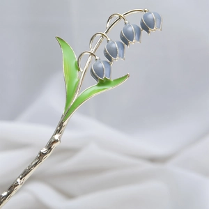 Elegante lelietjes-van-dalen haarspeld met groene bladeren en blauwe bloemen