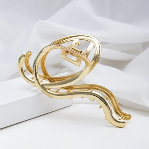 Minimalist irregular hollow metal shark hair claw clip in a glossy golden finish