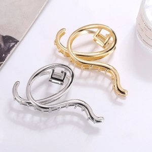 Minimalist gold and silver metallic irregular hair claw clips with elegant wavy design