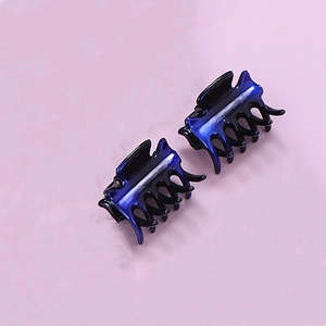 Detail view of small dark blue hair claws with metallic finish and toothed design