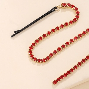 Detailed close-up of a long sparkling red rhinestone tassel chain with a black bobby pin hair clip
