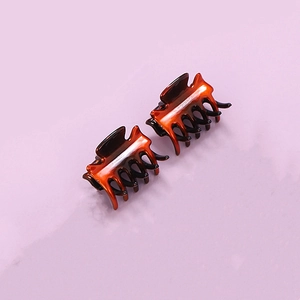 Close-up of small amber resin hair claw clips with classic tortoiseshell pattern detail