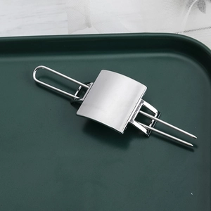 Minimalist geometric silver hollow metal hair pin with brushed finish on green tray