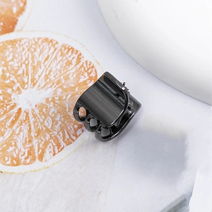 Mini Metall Haarklammer in Schwarz für Seitenfrisuren auf dekorativem floralem Untergrund