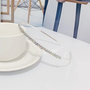 Vue détaillée d'un serre-tête en strass argentés posé sur une tasse en céramique