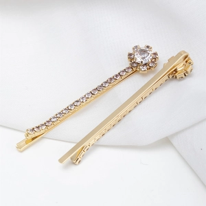 Elegante set di fermagli per capelli dorati con fiori di strass su raso bianco liscio