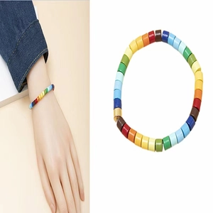 Detailed close-up of rainbow beaded bracelet with colorful cylinders and gold metal clasp