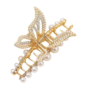 Detail der goldenen Schmetterlings-Haarklammer mit hohlen Flügeln und weißen Perlen