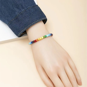 Rainbow beaded bracelet featuring colorful cylindrical beads on model wrist