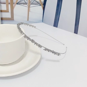 Serre-tête argenté élégant avec strass croisés étincelants au design ondulé